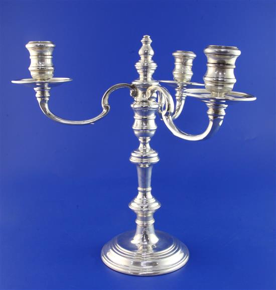 A modern 18th century style silver three branch, three light candelabrum by William Comyns & Sons Ltd, weighted.